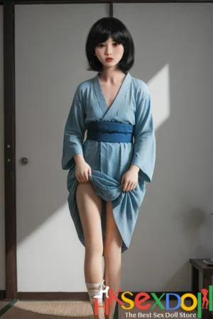 japanese petite sex doll with short black hair stands elegantly in a blue kimono outfit